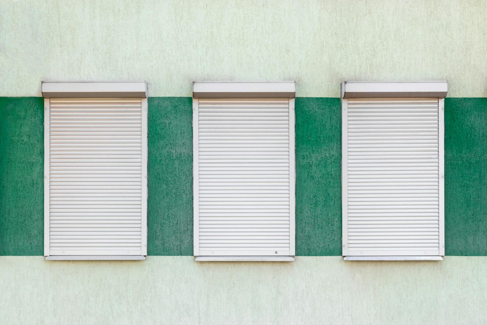 Drie gesloten rolluiken aan een gevel